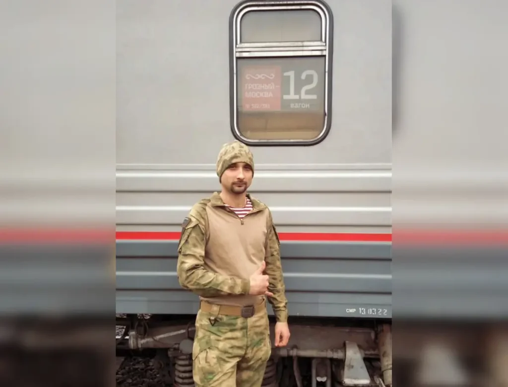 Никита Митченко позирует на фоне поезда «Грозный-Москва» в апреле 2022 года. Источник: личная страница ВКонтакте.